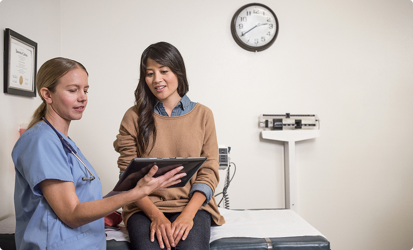 Nurse showing a patient information on a tablet.